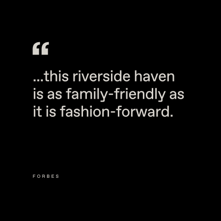 A black background with white text reads: "...this riverside haven is as family-friendly as it is fashion-forward." The word "Forbes" appears in small letters at the bottom left.