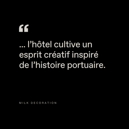 White French text on a black background reads: "... l'hôtel cultive un esprit créatif inspiré de l'histoire portuaire." Below, small text says: "Milk Decoration.